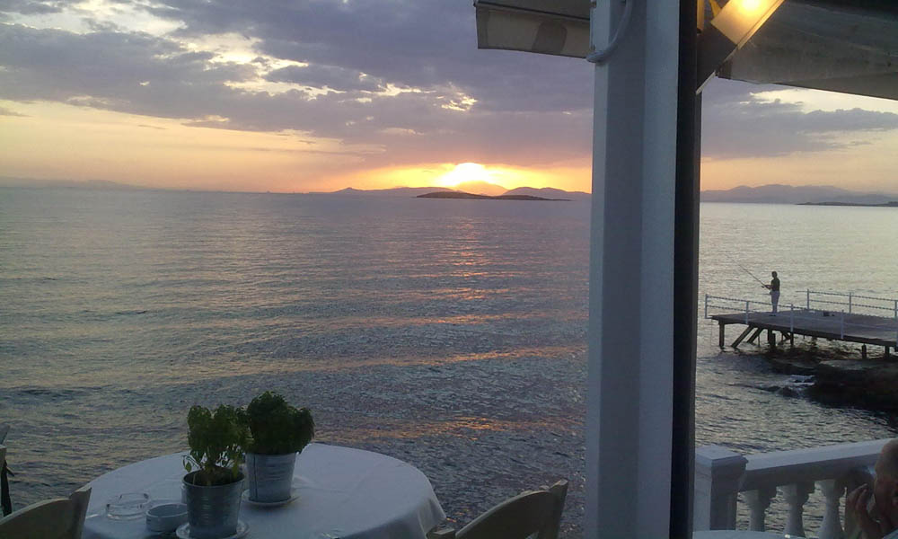 Βεράντα το σούρουπο με ψαρά στην προβλήτα